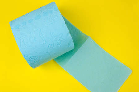 roll of blue  toilet paper on a yellow backgroundの写真素材