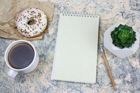 top view mock upnotebook with   blank  white paper sheet ,coffee cup and donutの写真素材