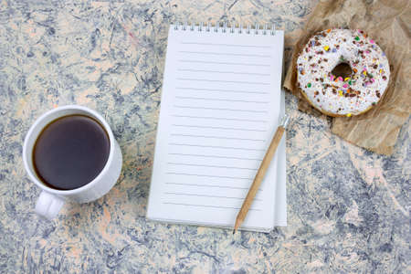 top view mock upnotebook with   blank  white paper sheet ,coffee cup and donutの写真素材