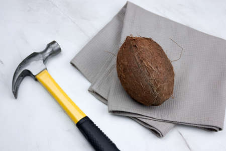 coconut and hammer  on a marble background top view