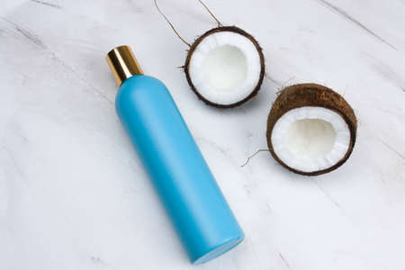 flat lay coconut and mock up blue plastic  bottle  on a  marble backgroundの写真素材