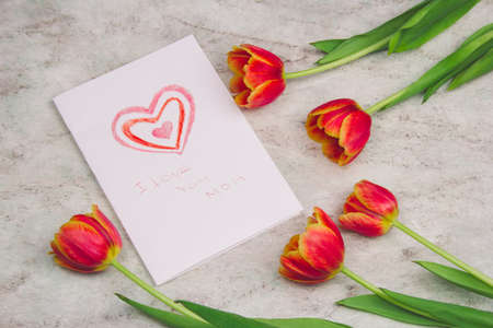 beautiful tulips and handmade card with kid's drawing  for Mother's Day on marble background, top viewの写真素材