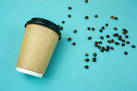 top view paper coffee to go cup  coffee beans on blue  backgroundの写真素材