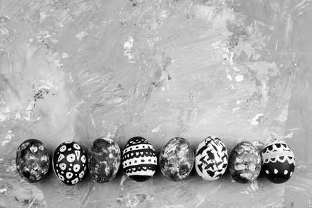 top view row of  dyed eggs with black and white geometric pattern on a concrete backgroundの写真素材