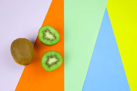 top view kiwi fruit on a vibrant multicolored stripped backgroundの写真素材