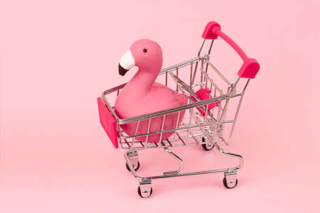 shopping cart with flamingo on pink pastel backgroundの写真素材