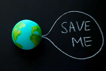 homemade model of the Earth planet on a chalkboard with the inscription save me,environmental conceptの写真素材
