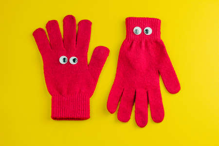top view of two gloves with eyes on a yellow backgroundの写真素材