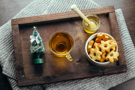 top view winter holiday breakfast tea,honey and star cookies on a wooden trayの写真素材