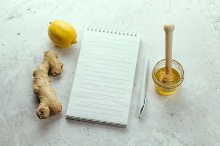 ginger,lemon, honey jar and blank mock up notebook top view flat lay