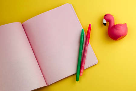 notebook with empty sheets, pencils and cute flamingo eraser on yellow background ,back to school mock upの写真素材