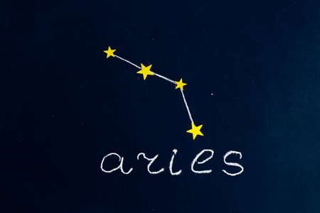 constellation Aries drawn in chalk and gold stars on a chalkboard looking like a night starry skyの写真素材