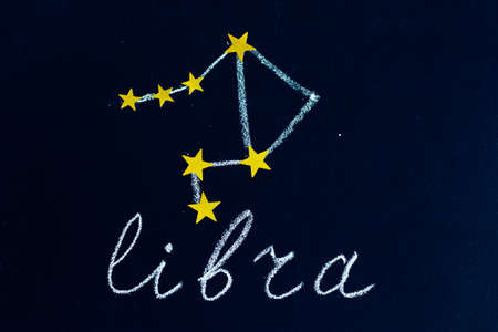 constellation Libra drawn in chalk and gold stars on a chalkboard looking like a night starry skyの写真素材