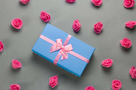 top view flat lay luxury blue present box with festive pink  satin ribbon bow and delicate pink...