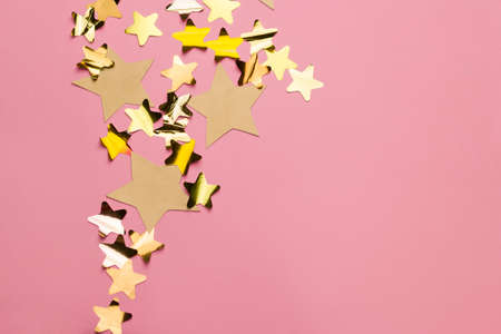 golden stars on a pink background with free space for textの写真素材