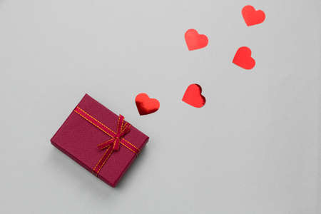 top view flat lay red gift box with red holographic hearts