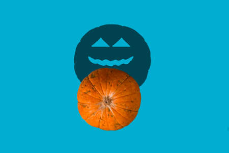 top view pumpkin with shadow with scary face on a blue background halloween cardの写真素材