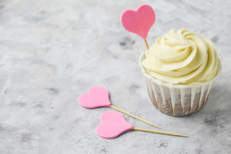 close up cupcake with pink heart on a gray concrete tableの写真素材