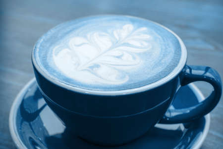 blue mug of blue matcha latte on a wooden table