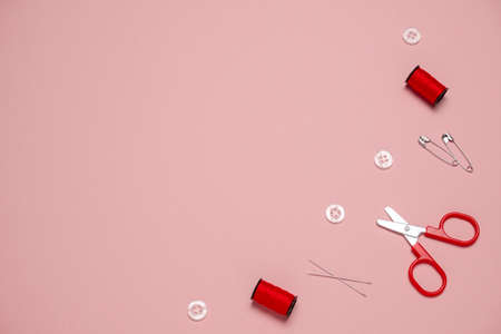 top view flat lay  sewing or embroidery supplies on a pink background with space for text