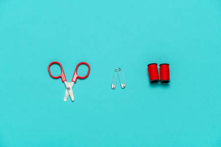 top view flat lay row of  sewing or embroidery supplies on a blue background with space for textの写真素材