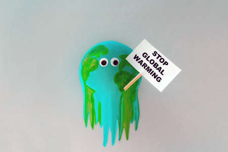 model of the planet Earth melts and holds a stop global warming signの写真素材