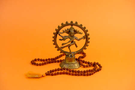statue of dancing God Shiva  and traditional prayer beads rudraksha on orange background , Shivaratri greeting cardの写真素材