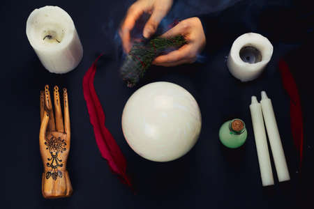 top view flat lay esoteric still life with candles,feather, potion,crystal ball, wooden hand and...
