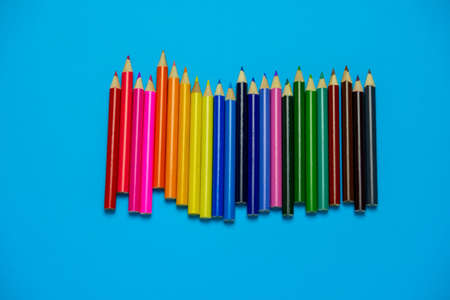 top view flat lay vibrant wooden multicolored pencils on a blue backgroundの写真素材