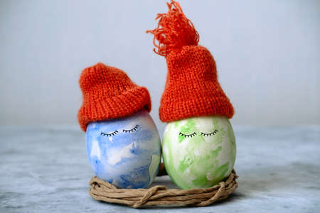 cute green and blue easter in orange knitted hatsの写真素材