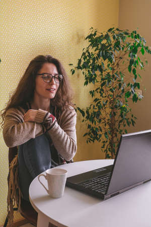 beautiful young woman wearing glasses and casual clothes using laptop, freelance conceptの写真素材