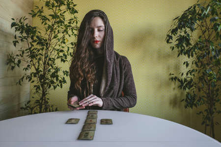 Tyumen, Russia, 12 February 2020 - woman with  layout of vintage cards with runes