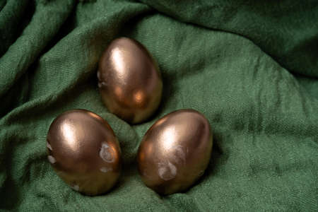 golden eggs on a green textile selective focus blurred background