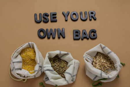 top view cereals in textile bags flat lay on a beige background, zero waste and no plastic bags...