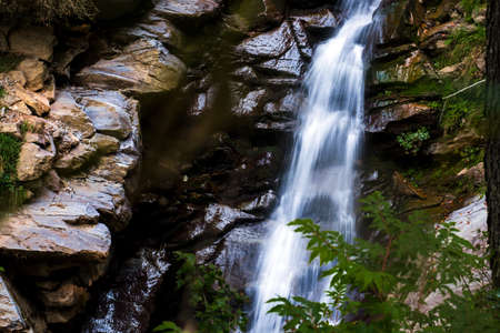 landscape with flowing water of waterfall in mountains
