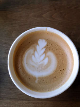 top view fresh coffee with milk foam art on a wooden background