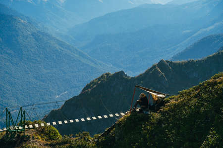 stunning landscape with mountains in the morning mist and a rope suspension bridge on the background of a precipice, a suspension bridge on the background of blurred mountainsの写真素材