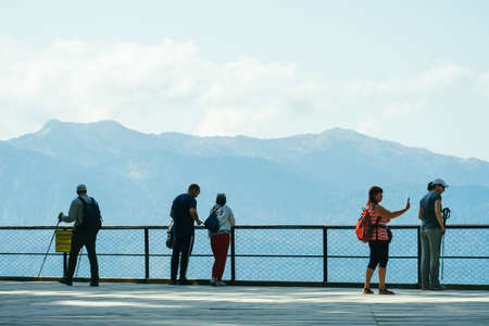 Sochi, Russia, 17 September 2020 - group of tourists standing on observation deck in mountains back to the camera, travel conceptの写真素材