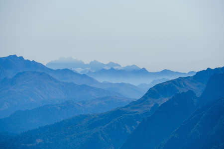 blurred abstract natural background with Caucasus Mountains in a morning blue mistの写真素材