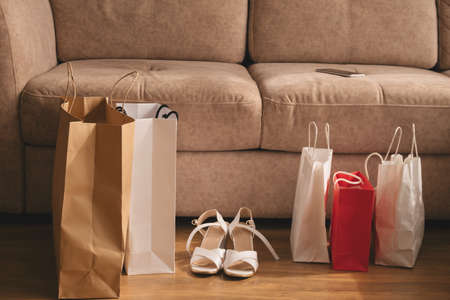 shopping bags and new shoes near sofa at home, shopping conceptの写真素材