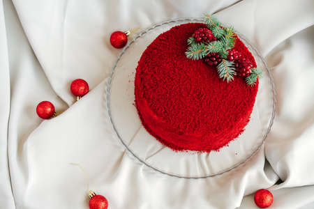 top view red velvet cake decorated with evergreen tree and pomegranate seeds on a gray background with christmas ballsの写真素材