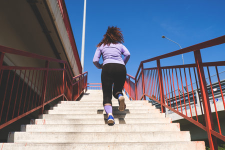back view young woman running on the stairs, sport conceptの写真素材