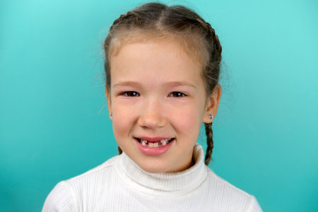 Studio head shot of little girl smiling on blue