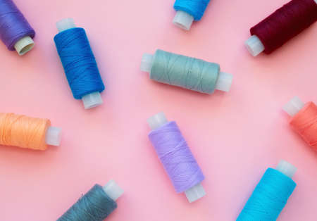 Collection of colored thread layout on a pink background. Handmade and sewing minimal concept.の写真素材