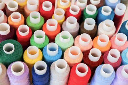 Colorful threads on spool close-up. Handmade and sewing wallpaper. Selective focus.の写真素材