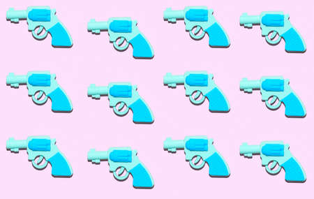 Top view flat lay blue gun with shadow pattern on a pink pastel background.