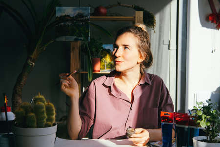Beautiful woman drawing in art studio. Hobby and art concept.の写真素材