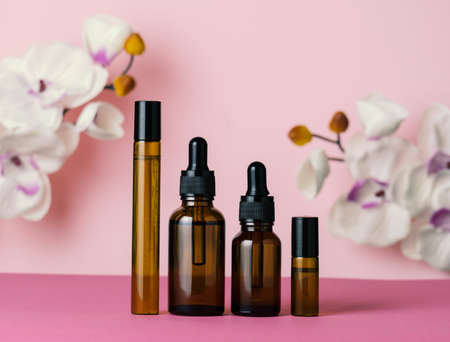 Brown glass bottles on a pink background. Beauty care concept.