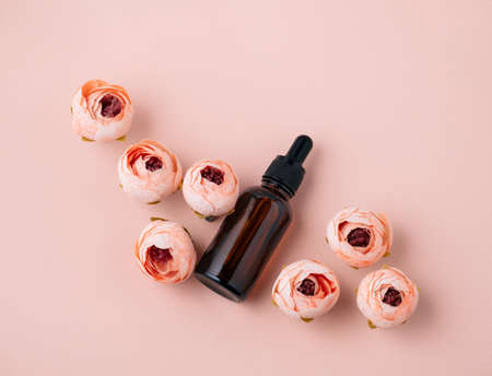 Top view flat lay cosmetic oil bottle and roses soft pink background. Beauty care conceptの写真素材