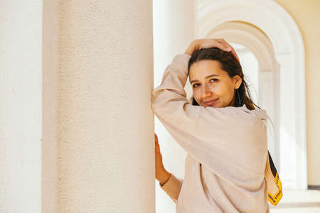 Portrait beautiful young woman weaing casual velvet jacket standing near column. Lifestyle mochrome portrait.の写真素材